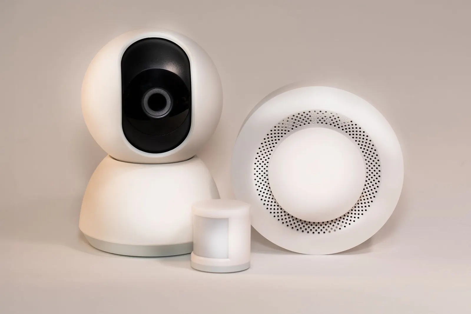 Components of a modern wireless alarm system: hub, motion sensor, indoor camera and siren